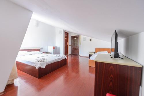 a bedroom with two beds and a flat screen tv at Vila Blue Eforie Nord in Eforie Nord