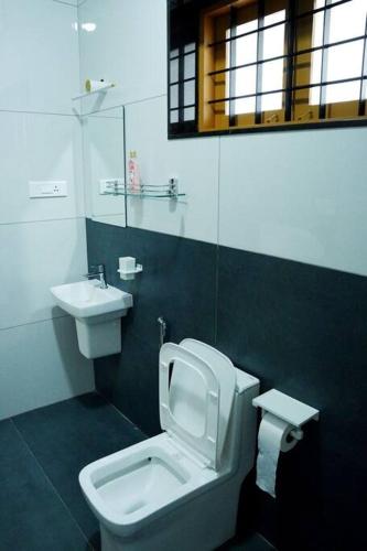 a bathroom with a toilet and a sink at Crystal Villa Suite1 Ground floor in Cochin