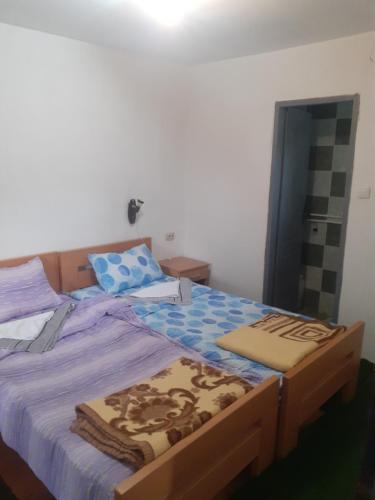 een slaapkamer met een bed met een blauw dekbed bij Stara planina, smestaj Ćirković in Pirot
