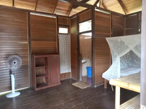 an inside view of a wooden cabin with a fan at Lorenso Cottage in Manado