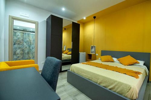 um quarto com uma cama e uma parede amarela em Domus Martì em Formia