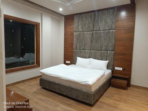 um quarto com uma cama e uma janela em Hotel Endora em Patiala