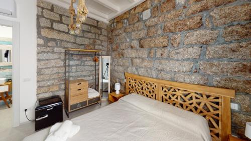 a bedroom with a brick wall with a bed in it at Residenze Civitas in Olbia