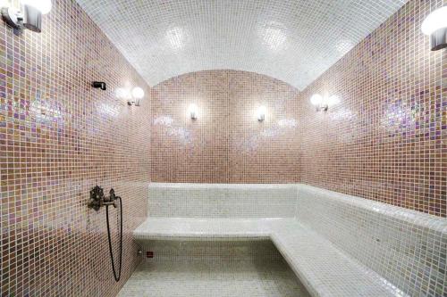 a bathroom with a tub in a room with tiles at Holiday Inn Baku by IHG in Baku