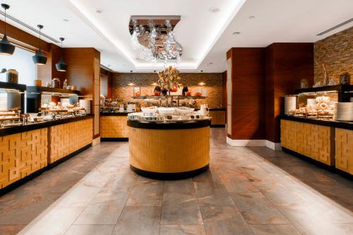 a restaurant with a counter in the middle of a room at Holiday Inn Baku by IHG in Baku