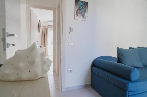 a blue couch in a living room with a mirror at VeMi Affittacamere in Posada