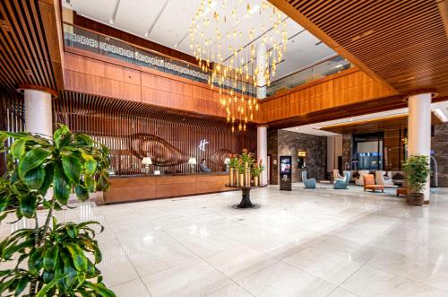 巴庫的住宿－巴庫假日酒店，带有植物和吊灯的酒店大厅