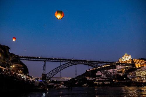 a kite flying over a bridge over a river at CELLARS CENTER HOUSE in Vila Nova de Gaia