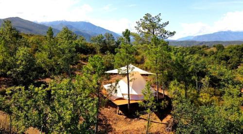 une tente dans un champ avec des montagnes en arrière-plan dans l'établissement Grande Tente Tipi avec magnifique vue, à Rigarda