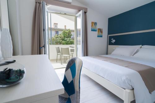 a bedroom with a bed and a table and a balcony at VeMi Affittacamere in Posada