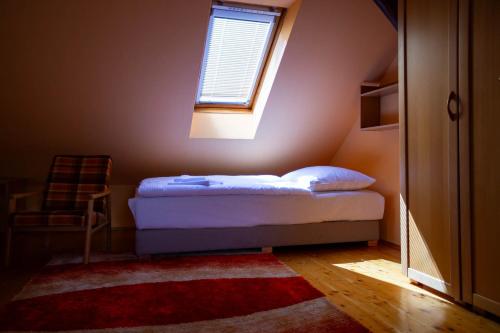 a small bedroom with a bed and a window at Apartmán NIKA in Levoča