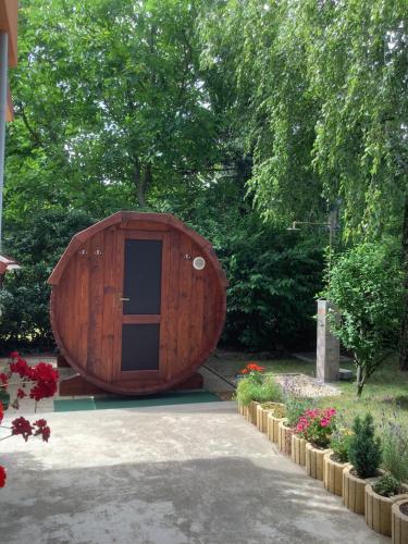 duży drewniany budynek z drzwiami w ogrodzie w obiekcie Rita Apartman w Gyenesdiás