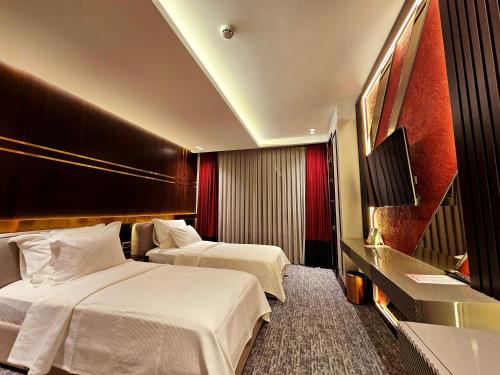 Midyat的住宿－Asur Imperıal Hotel，酒店客房设有两张床和电视。