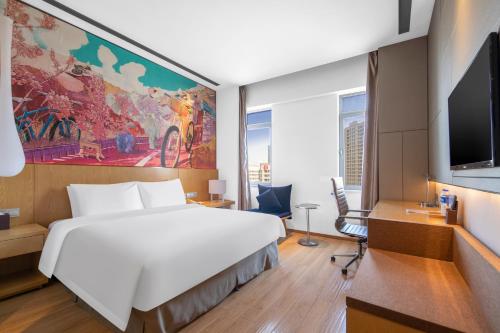 a hotel room with a large bed and a flat screen tv at Minimax Hotel Shanghai Songjiang in Songjiang