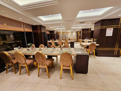 Asur Imperıal Hotel في مِديات: غرفة طعام كبيرة مع طاولات وكراسي
