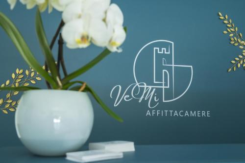 a white vase with white flowers on a table at VeMi Affittacamere in Posada