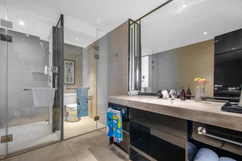 ein Bad mit einer Dusche, einem Waschbecken und einem WC in der Unterkunft Minimax Hotel Shanghai Songjiang in Songjiang