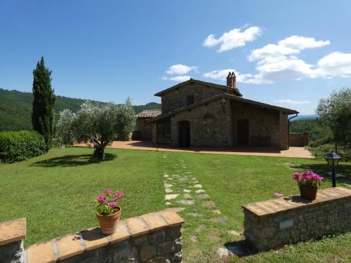 uma vista exterior de uma casa de pedra com flores em Scappo in Umbria, la Vallata em Parrano