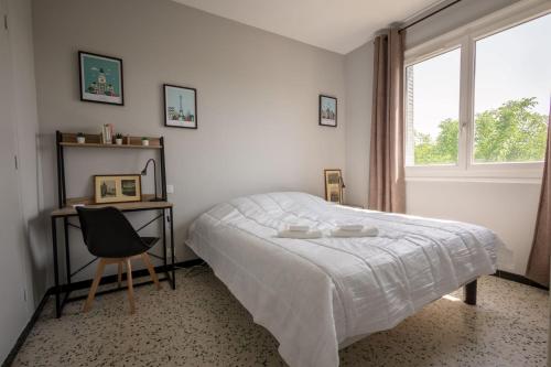Schlafzimmer mit einem Bett, einem Schreibtisch und einem Fenster in der Unterkunft ღ Le Santa Cruz • Spacieux T3 • Parking & Wi-Fi in Pierrelatte