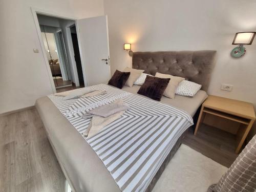 a bedroom with a large bed with striped sheets and pillows at Apartment Lučka in Rab