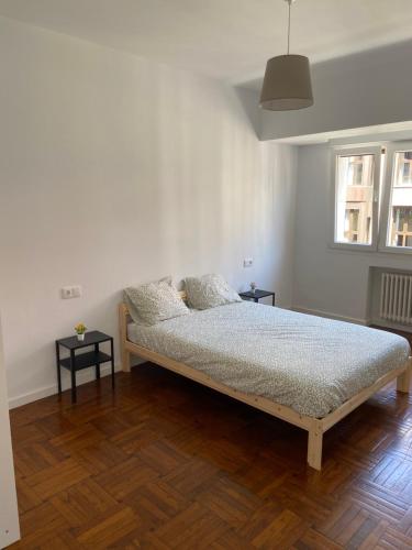 1 dormitorio con 1 cama y 2 mesas. en Amplio apartamento en La Arena, 4 hab, en Gijón