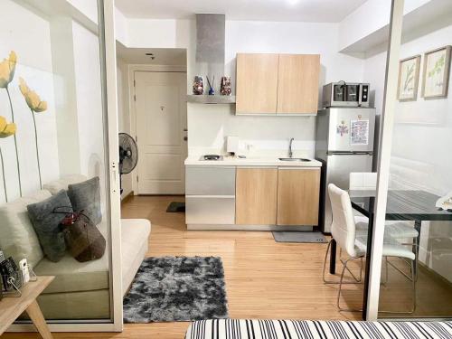 a small kitchen with a table and a refrigerator at Azure Staycation Magical Suite in Manila