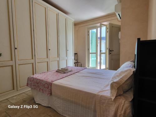 um quarto com uma cama e uma grande janela em Queen House em Montopoli in Val dʼArno