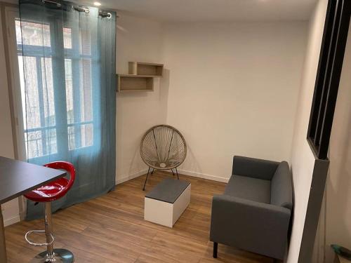 een woonkamer met een stoel en een stoel bij Appartement refait à neuf in Argelès-sur-Mer