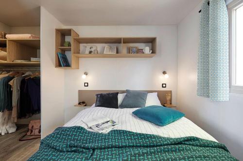 濱海拉福特的住宿－Camping Paradis Le Grand' R，一间卧室配有一张带蓝色枕头的床