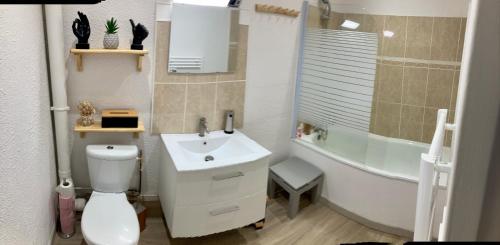 a bathroom with a sink and a toilet and a tub at Petite maison VILLEFORT in Villefort