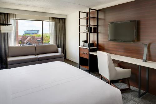 a hotel room with a bed and a tv at Marriott East Lansing at University Place in Lansing