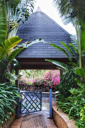 a blue gate in a garden with plants at Grand Hotel Haikou - Managed by Accor in Haikou