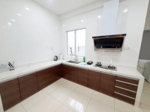 a large white kitchen with a sink and a counter at MODERN STYLISH 2STOREY HOUSE 8PAX@ALMA NEAR JUSCO in Bukit Mertajam