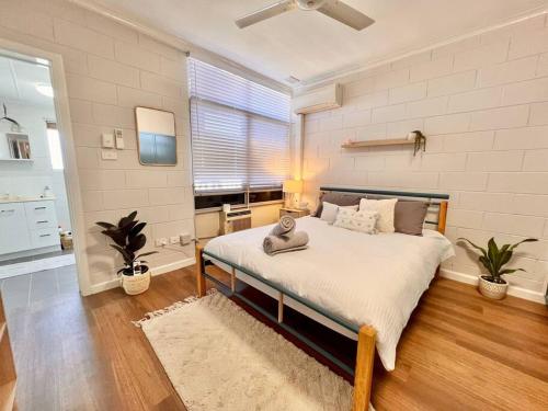 una camera da letto con un letto e un gatto seduto sopra di Stylish Apartment by the sea a Port Hedland