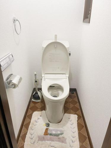 a bathroom with a toilet with a rug on the floor at Tatami room & Living Room equipped with Multinational TV and Fire, BBQ corner in Tokyo Downtown House in Tokyo