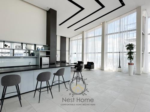a lobby with a counter and chairs in a room at Twin Tower Residence by Nest Home【5 mins walk to CIQ】 in Johor Bahru