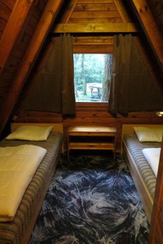 a room with two beds and a window in a cabin at Nowa Holandia in Sieraków