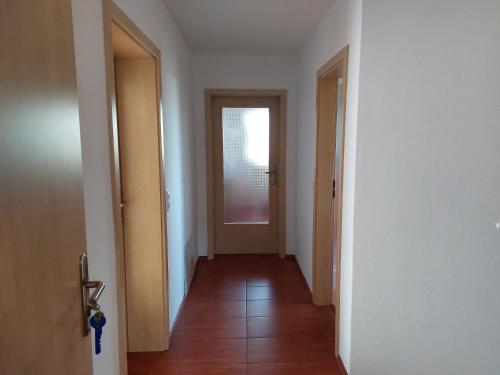 an empty hallway with a door and a hallwayngth at Apartmán 65 Hartmanice in Hartmanice