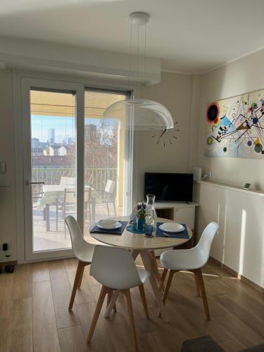 a dining room with a table and chairs with a view at Attico Gabri - Appartamento con terrazzo panoramico vicino al Centro in Turin
