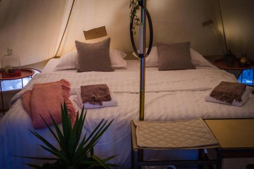 1 dormitorio con 1 cama blanca grande con almohadas en Rock Oak Camp en Imotski