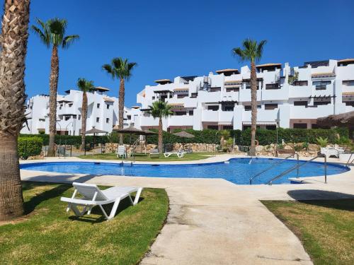 un complexe avec une piscine et des palmiers dans l'établissement Ático Loft Vera Playa, à Vera