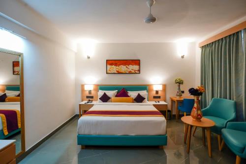 a hotel room with a bed and a table and chairs at Hotel Meraden Opus , Anjuna Beach Goa in Anjuna