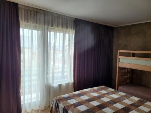 a bedroom with a bed and a window with curtains at Townhouse in Mountains. in Bakuriani