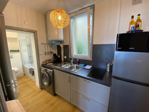 une cuisine avec un évier et un réfrigérateur dans l'établissement Studio Papillon en plein cœur de ville, à Saint-Omer