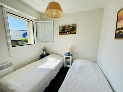 deux lits dans une petite pièce avec une fenêtre dans l'établissement Quiberon - Appartement 3 pièces, 41m², 2 chambres, terrasse, parking, animaux admis - FR-1-478-95, à Quiberon