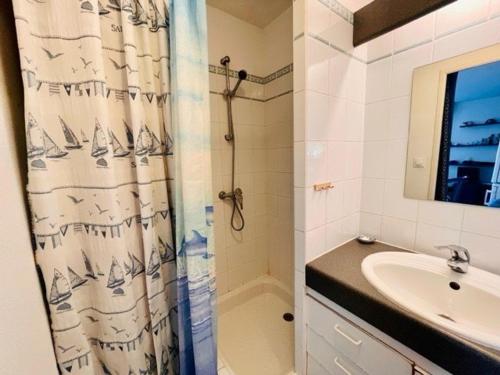 une salle de bain avec un rideau de douche et un lavabo dans l'établissement Quiberon - Appartement 3 pièces, 41m², 2 chambres, terrasse, parking, animaux admis - FR-1-478-95, à Quiberon