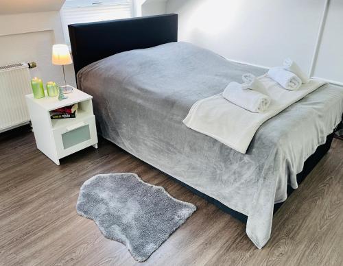 1 dormitorio con cama grande y mesita de noche blanca en Schönes zentrales Appartment mit TIEFGARAGE, en Kassel
