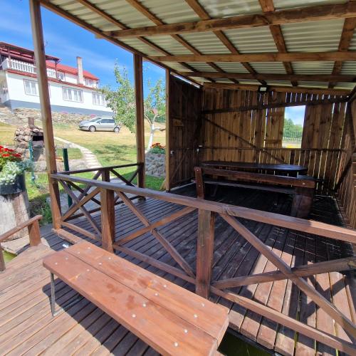 a wooden porch with a bench on a deck at Griežto 5 in Zarasai