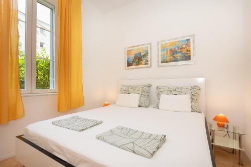 a white bed in a room with a window at Guest House Cinema close to port in Dubrovnik