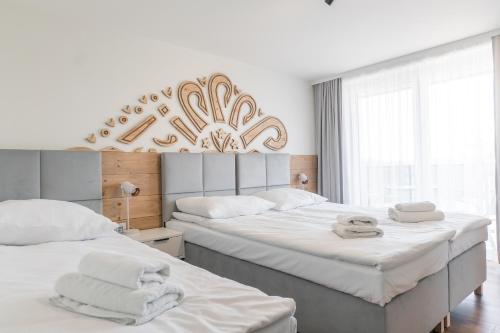 ein Schlafzimmer mit 2 Betten und Handtüchern darauf in der Unterkunft Apartamenty Przy Ścieżce Velo Czorsztyn in Dębno